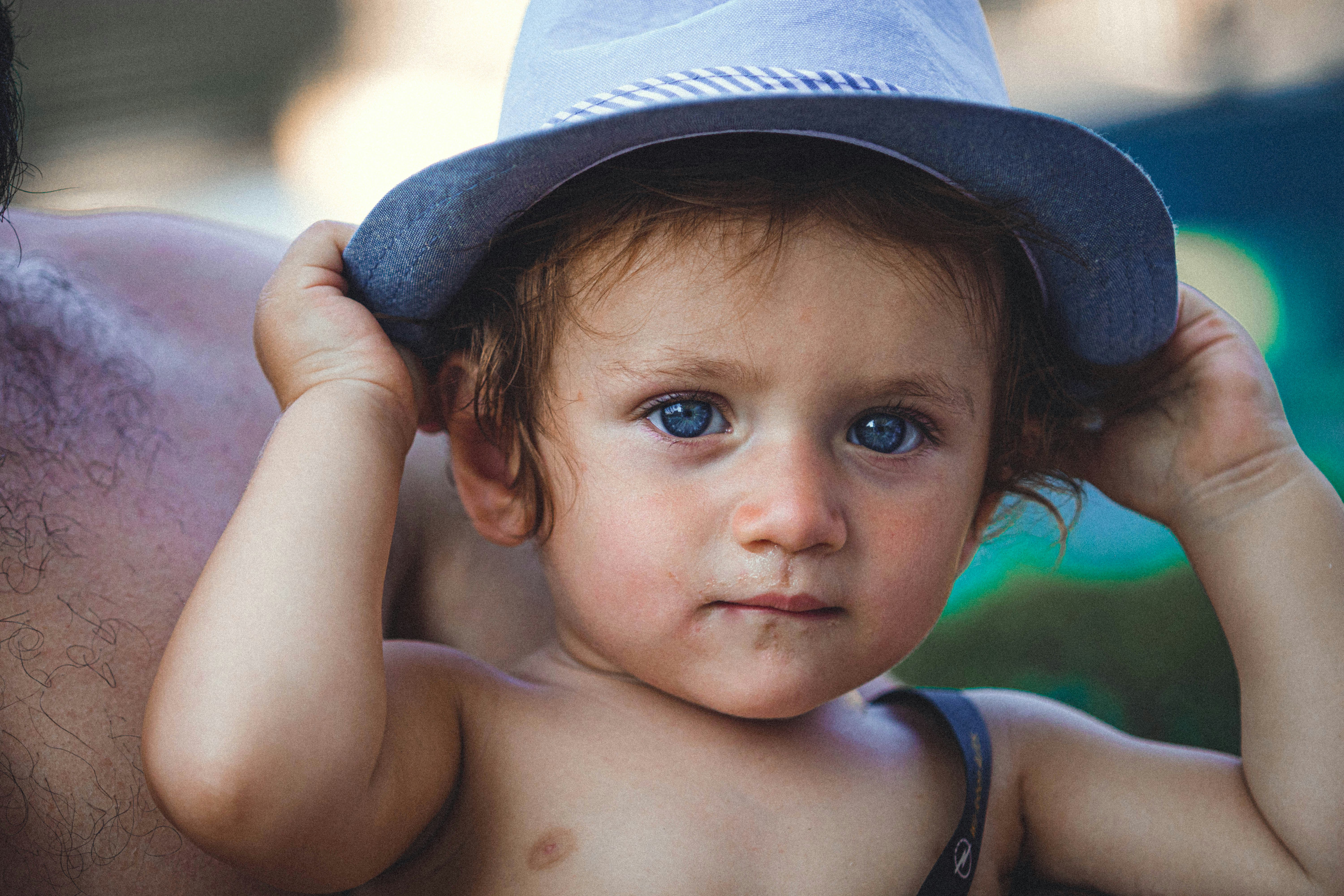 a man holding a baby wearing a hat