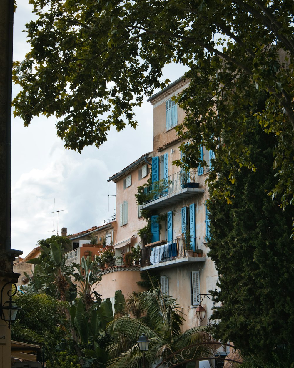 a tall building with blue shutters next to trees