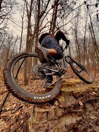 A rider launching off a steep rocky drop with intense focus and determination.