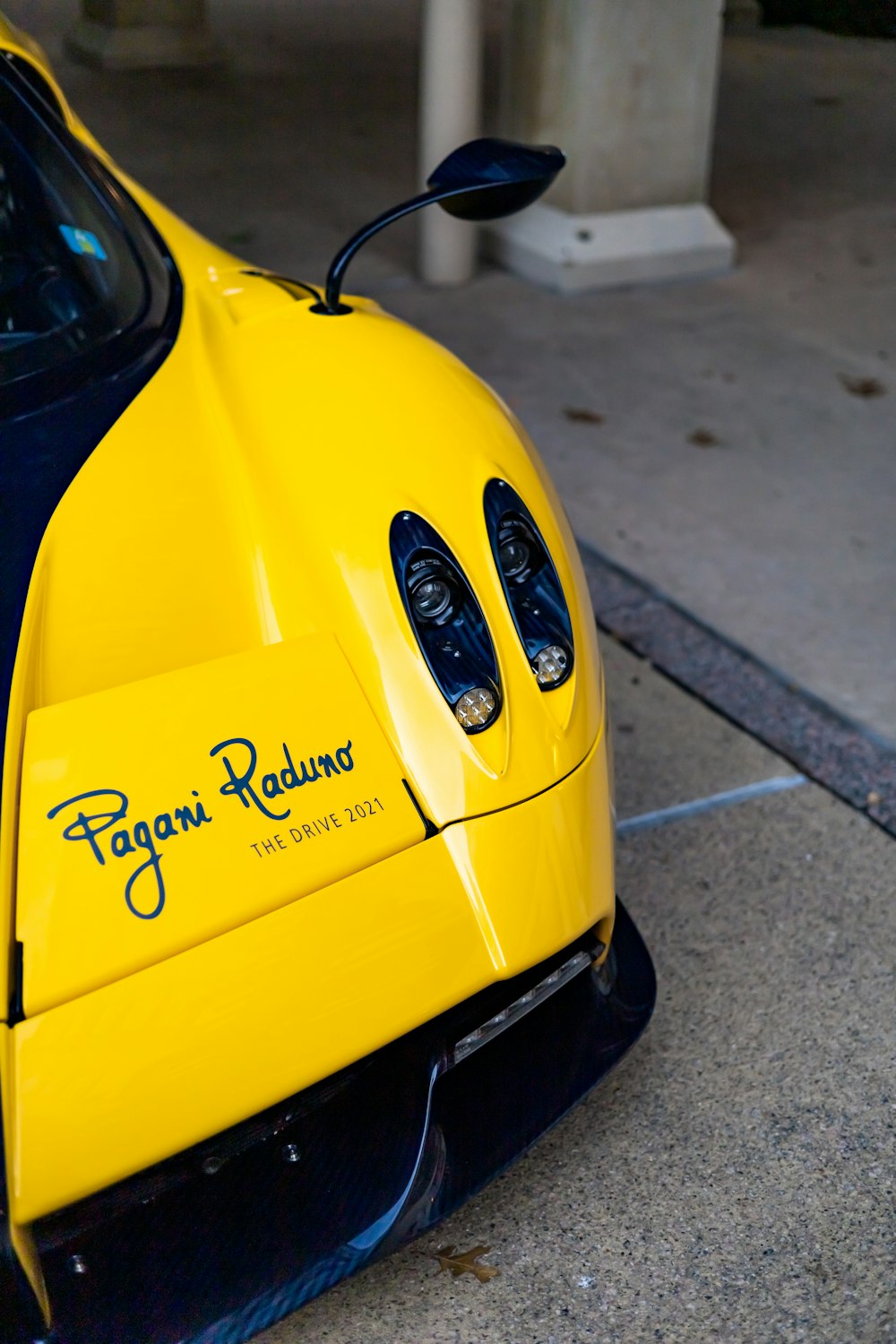 a yellow and black sports car parked on the side of the road