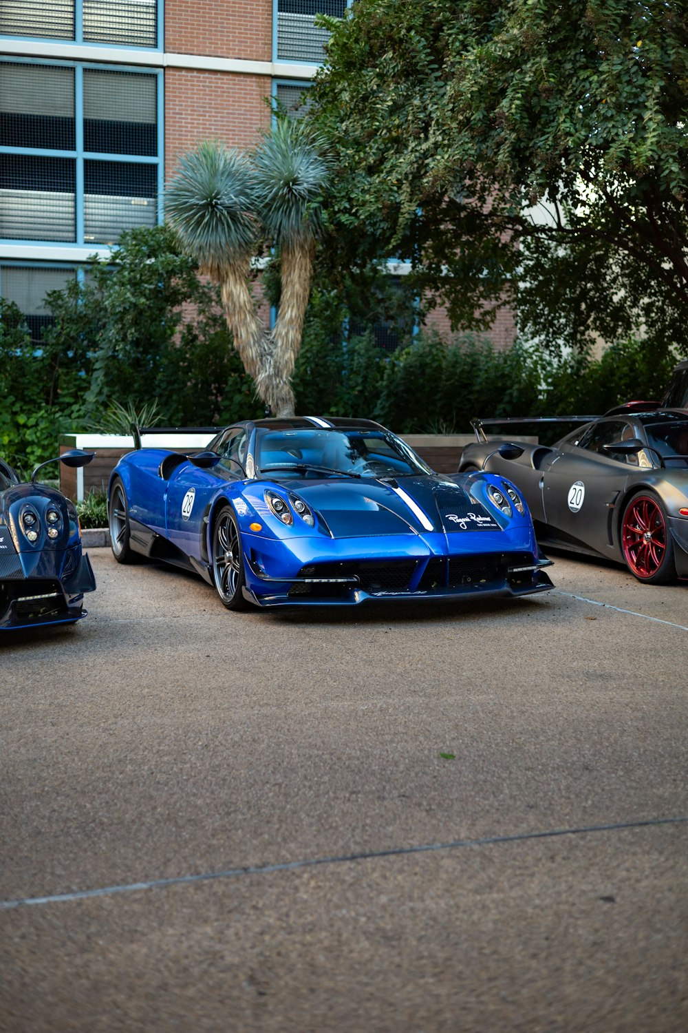 three blue sports cars parked in a parking lot