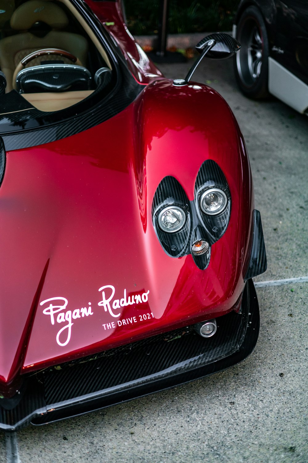 a close up of a red sports car on a street