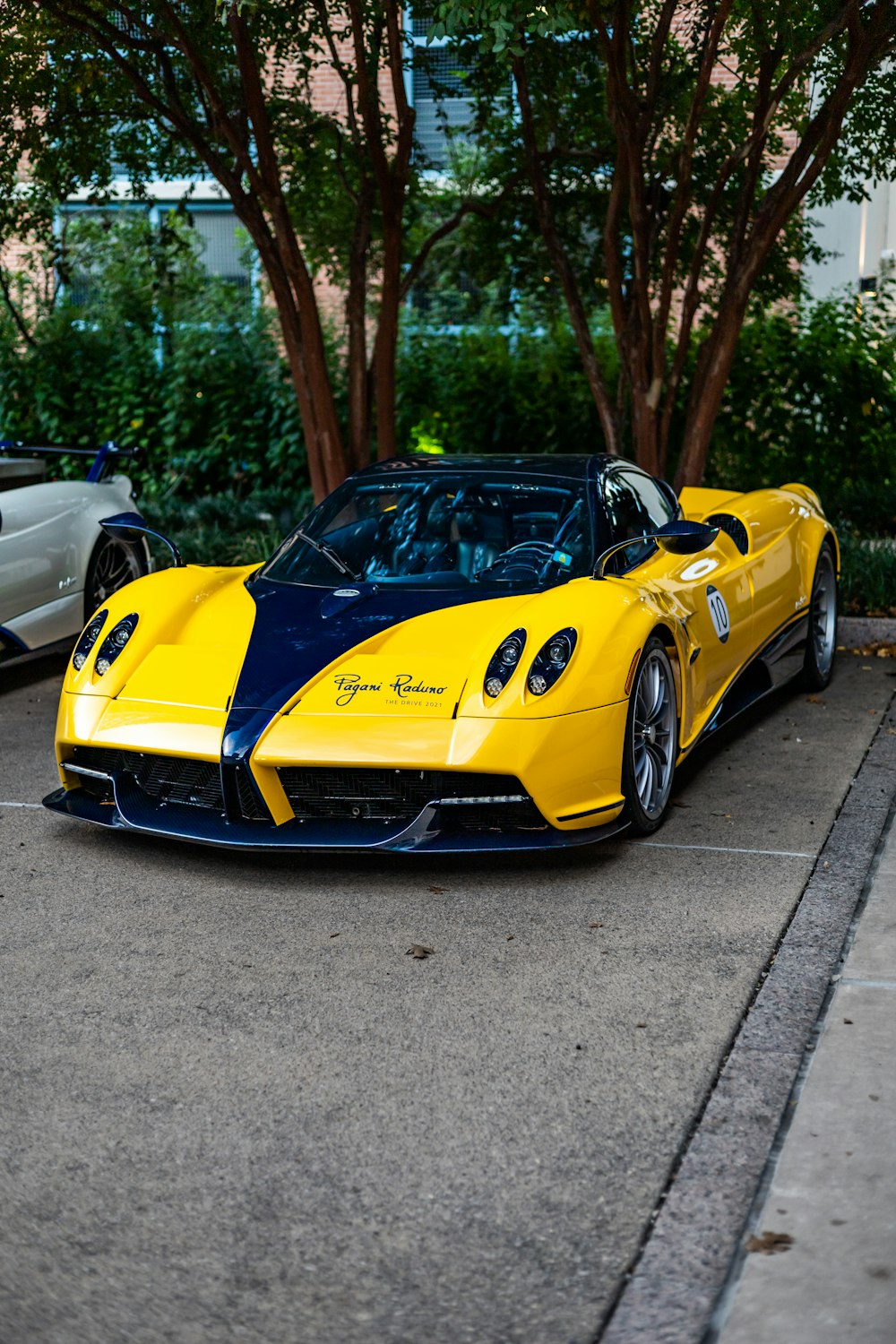 a yellow and blue sports car parked in a parking lot