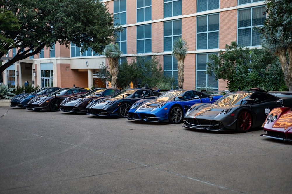 a row of sports cars parked in front of a building