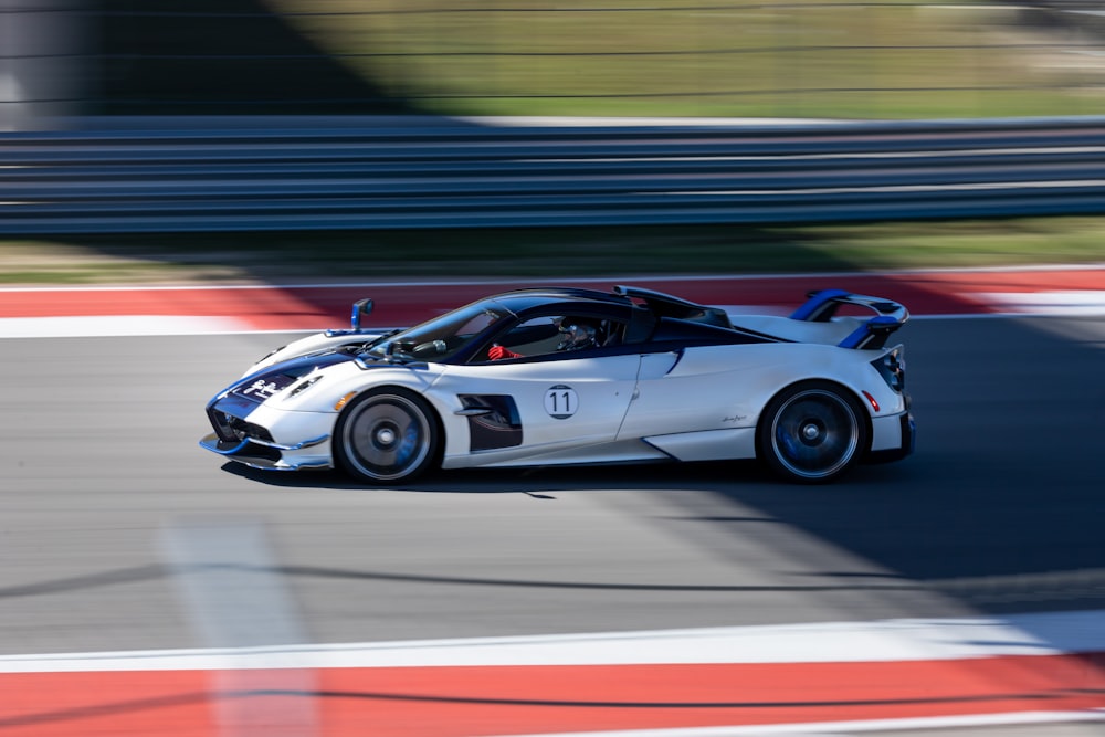 a white sports car driving on a race track