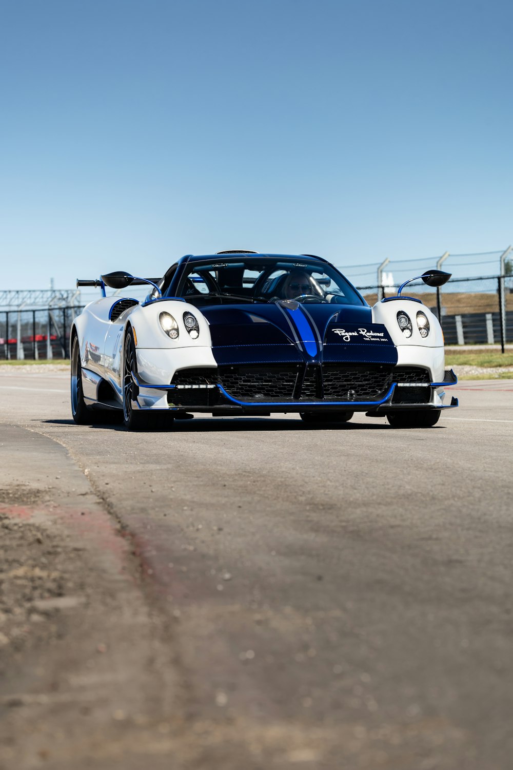 a blue and white sports car on a race track