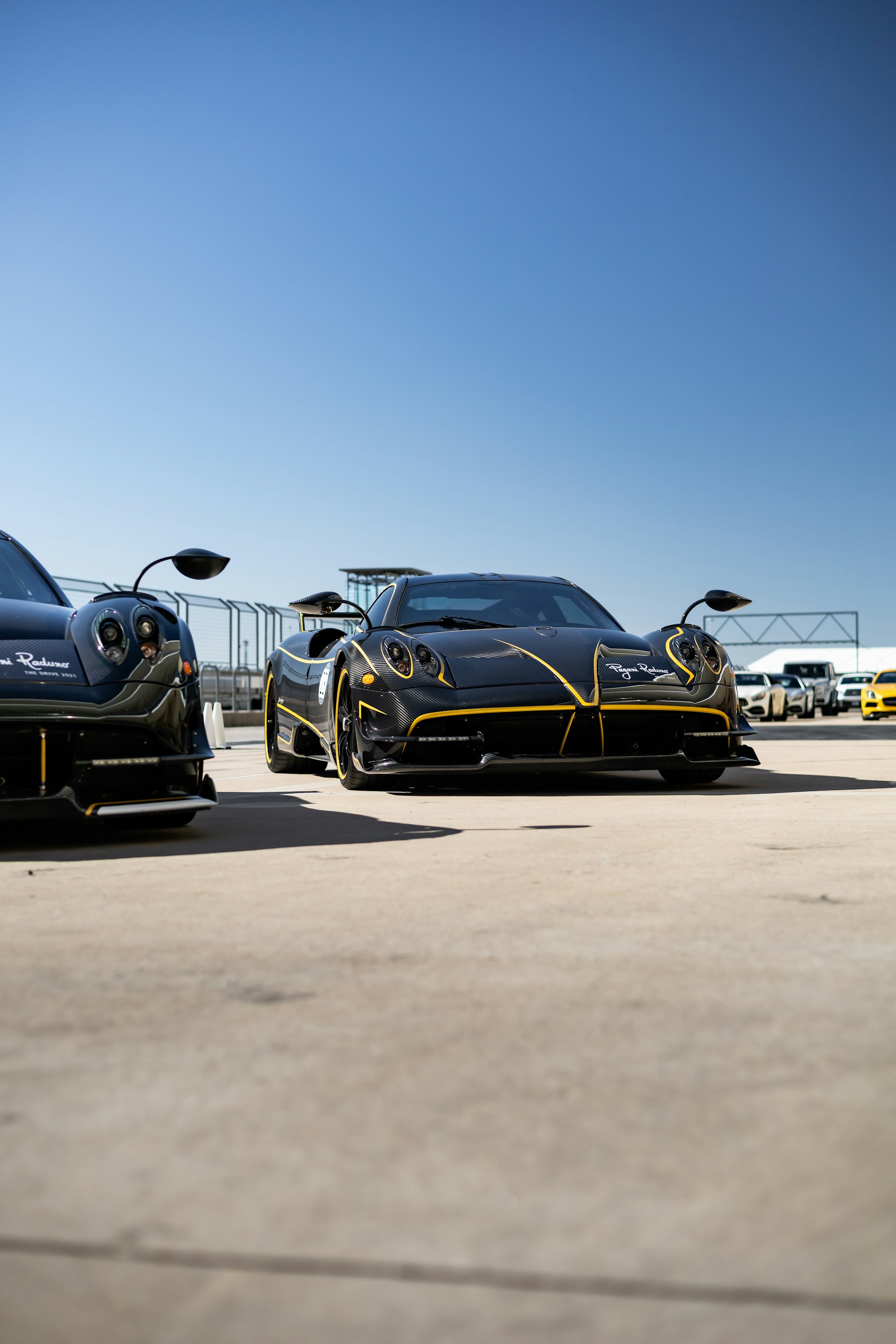 A sleek black sports car parked on a racetrack, showcasing its aerodynamic design.