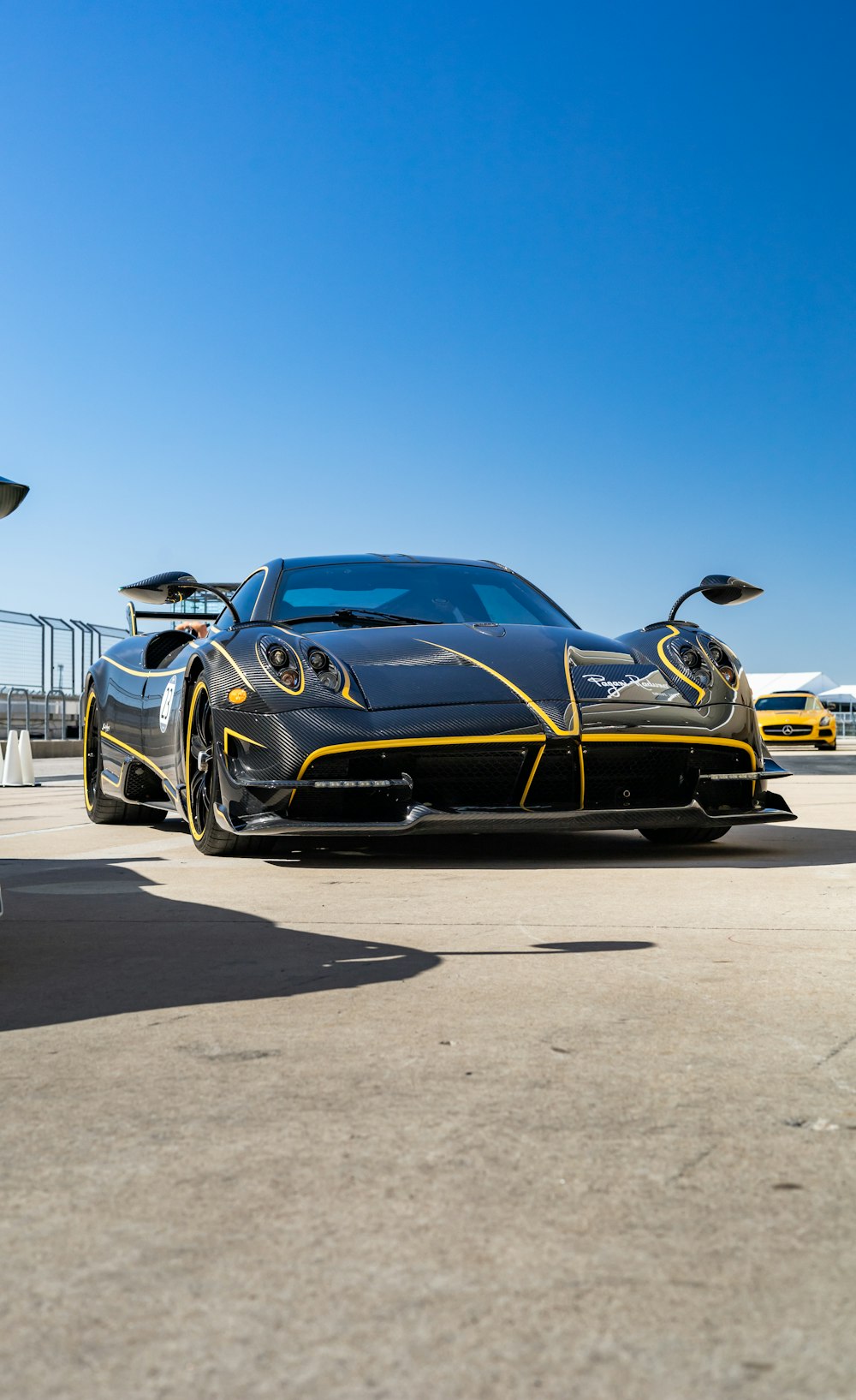 a black and yellow sports car parked in a parking lot