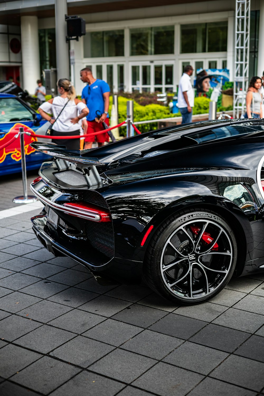 Ein schwarzer Sportwagen parkt vor einem Gebäude