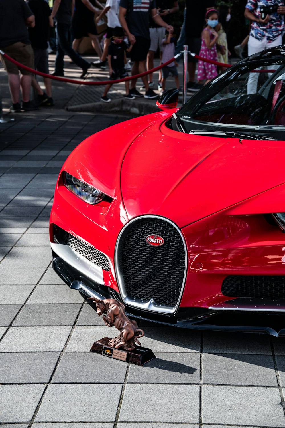 a red sports car parked in front of a crowd of people