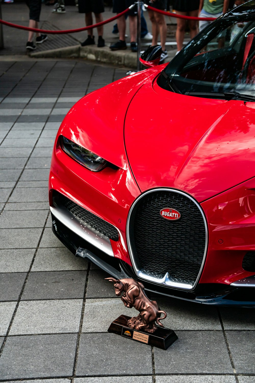 a red sports car with a statue of a monkey on the front