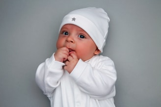 a baby is dressed in a white outfit