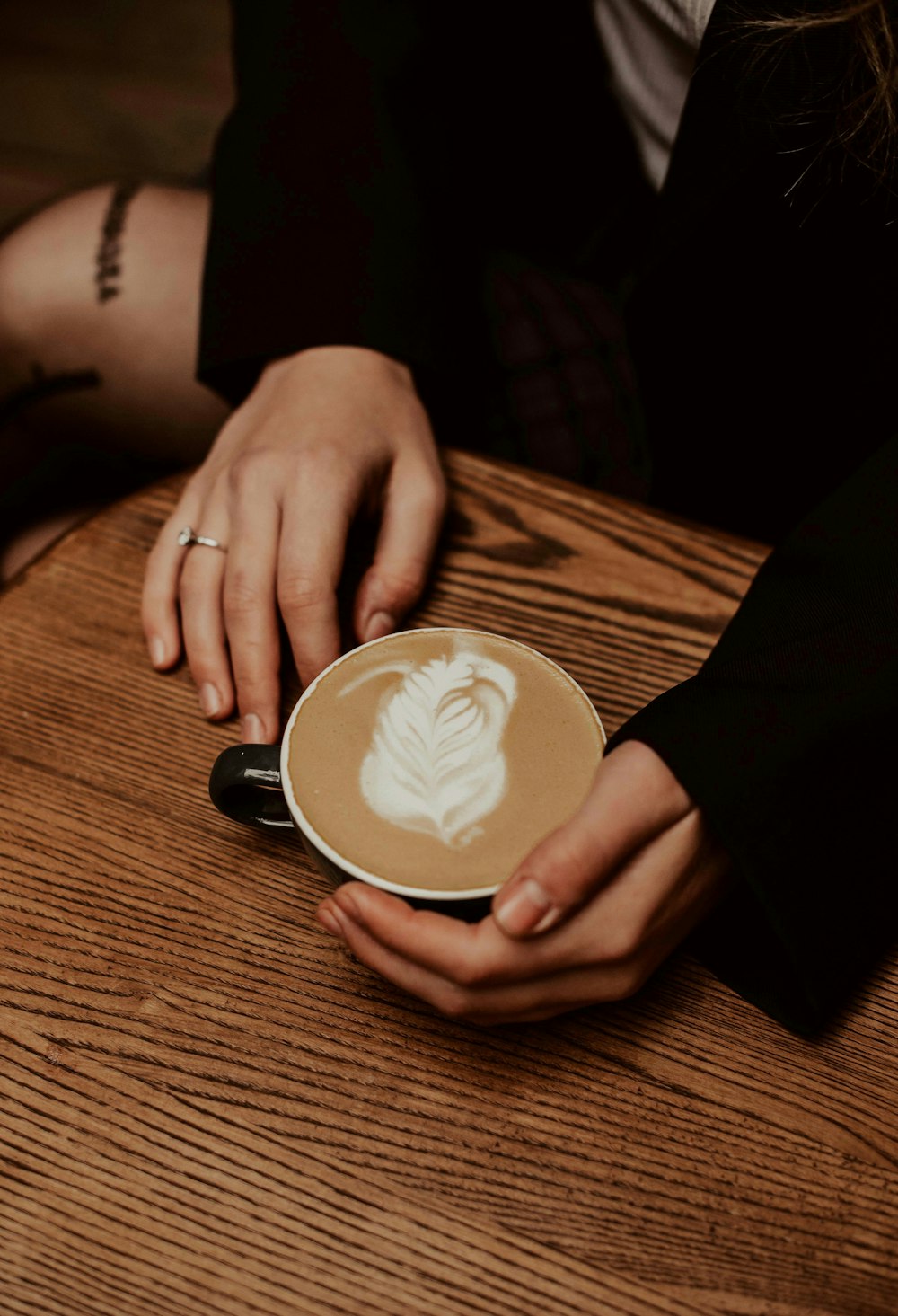 a person sitting at a table with a cup of coffee