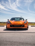 an orange sports car parked on the side of the road