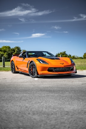 an orange sports car parked on the side of the road