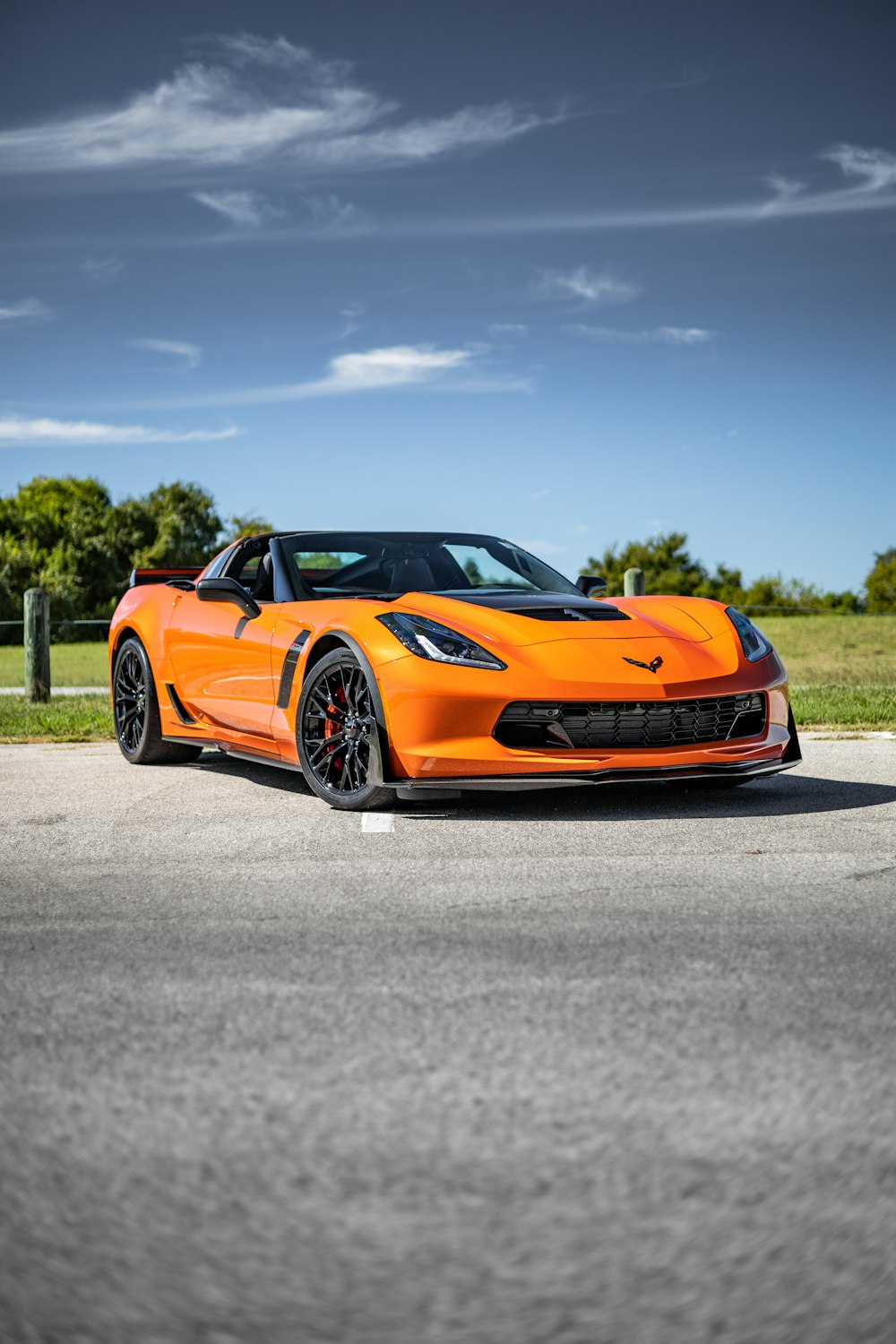 an orange sports car parked on the side of the road