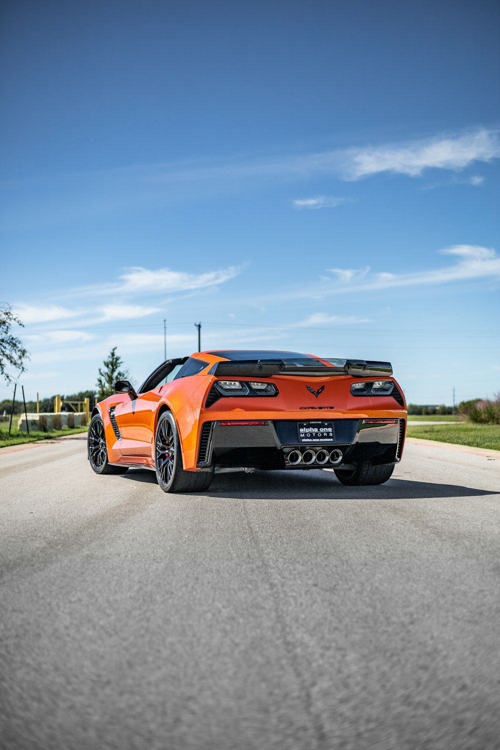 an orange sports car driving down a road