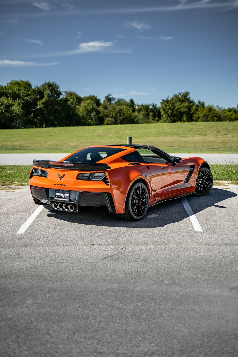 an orange sports car parked in a parking lot