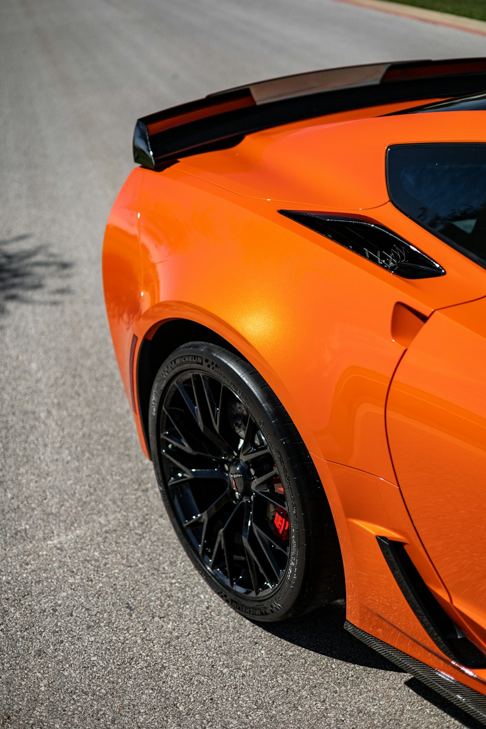 an orange sports car parked on the side of the road