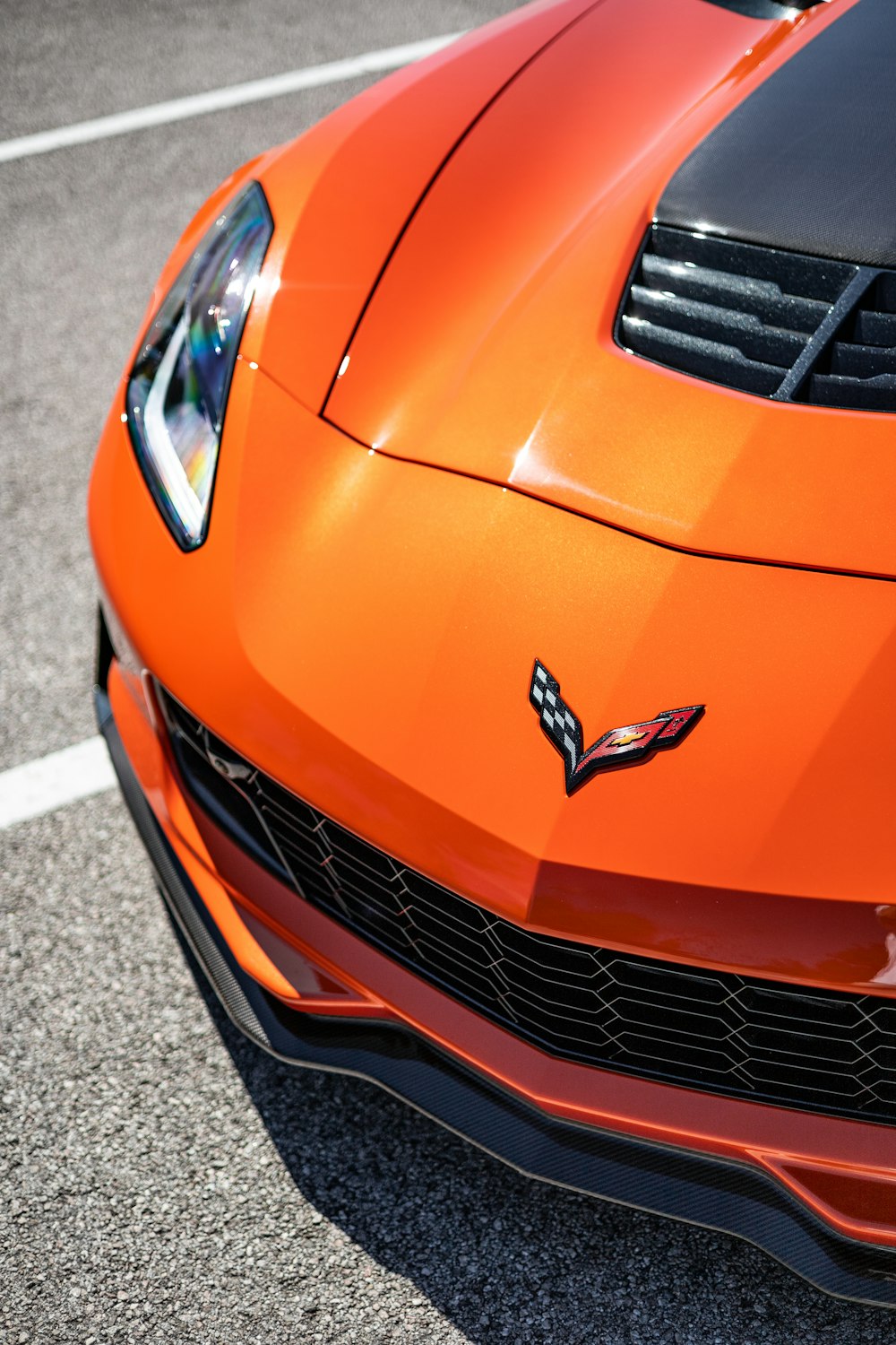 a close up of the front of an orange sports car