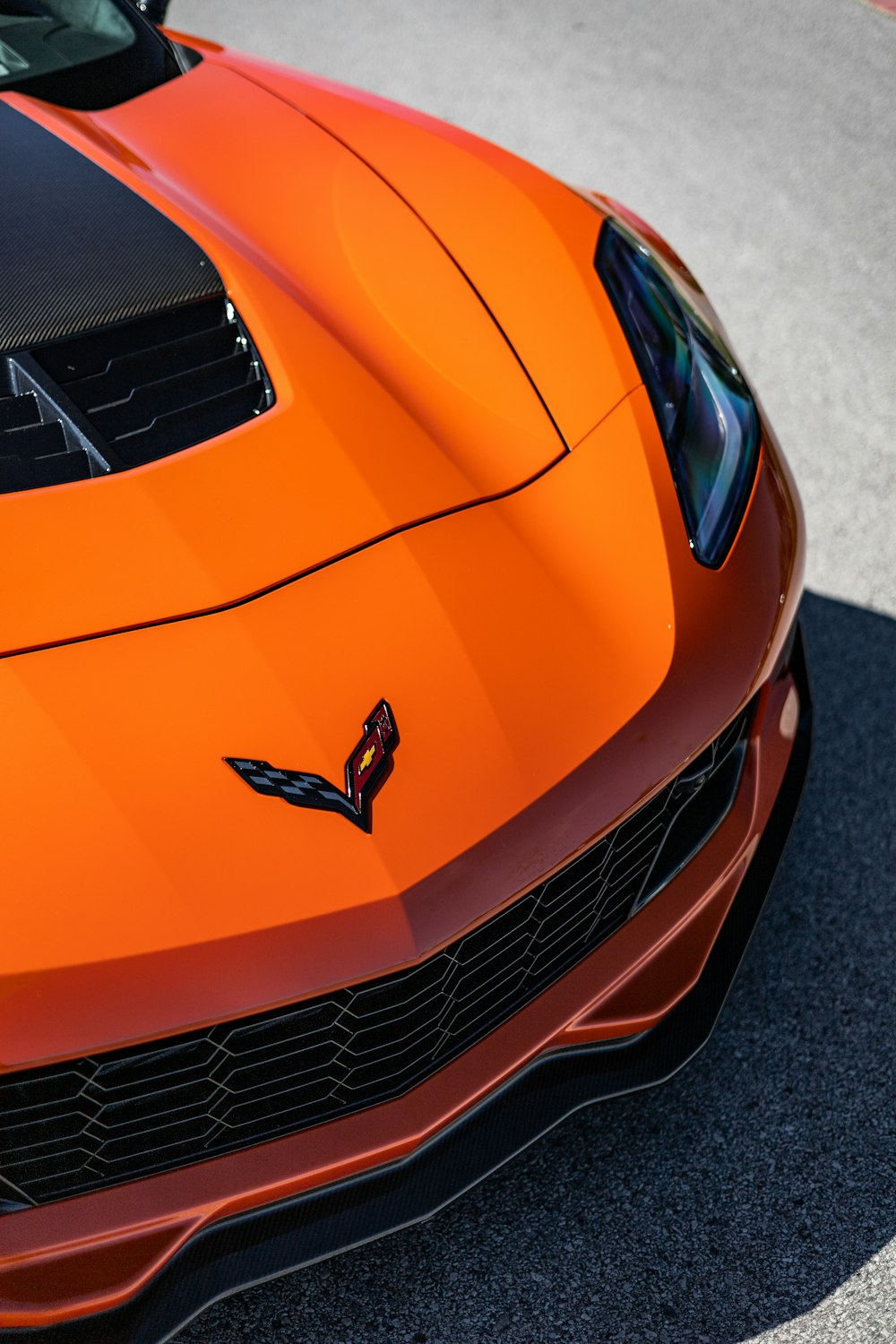 um close up do capô de um carro esportivo laranja