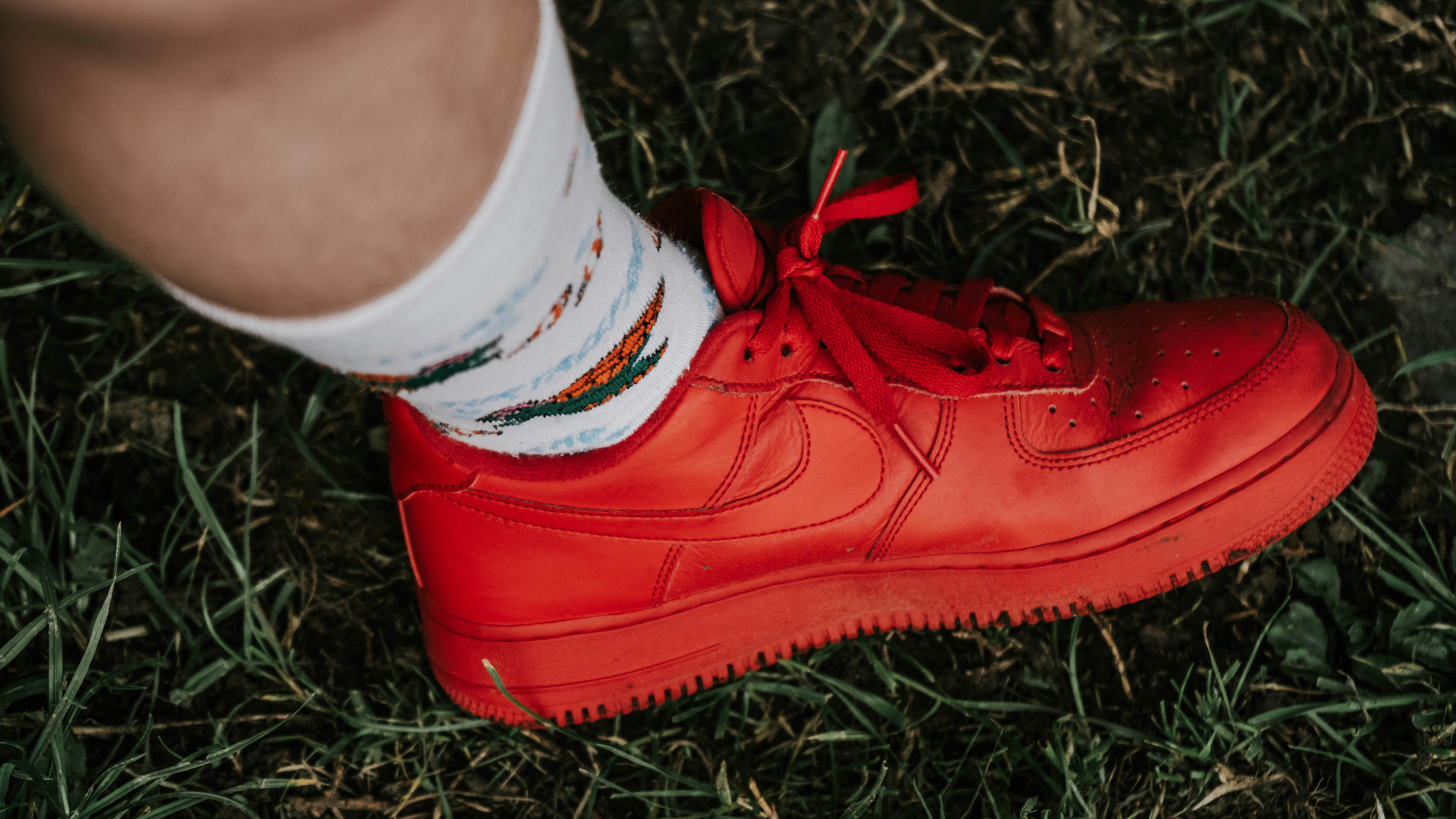 a person wearing red sneakers and white socks