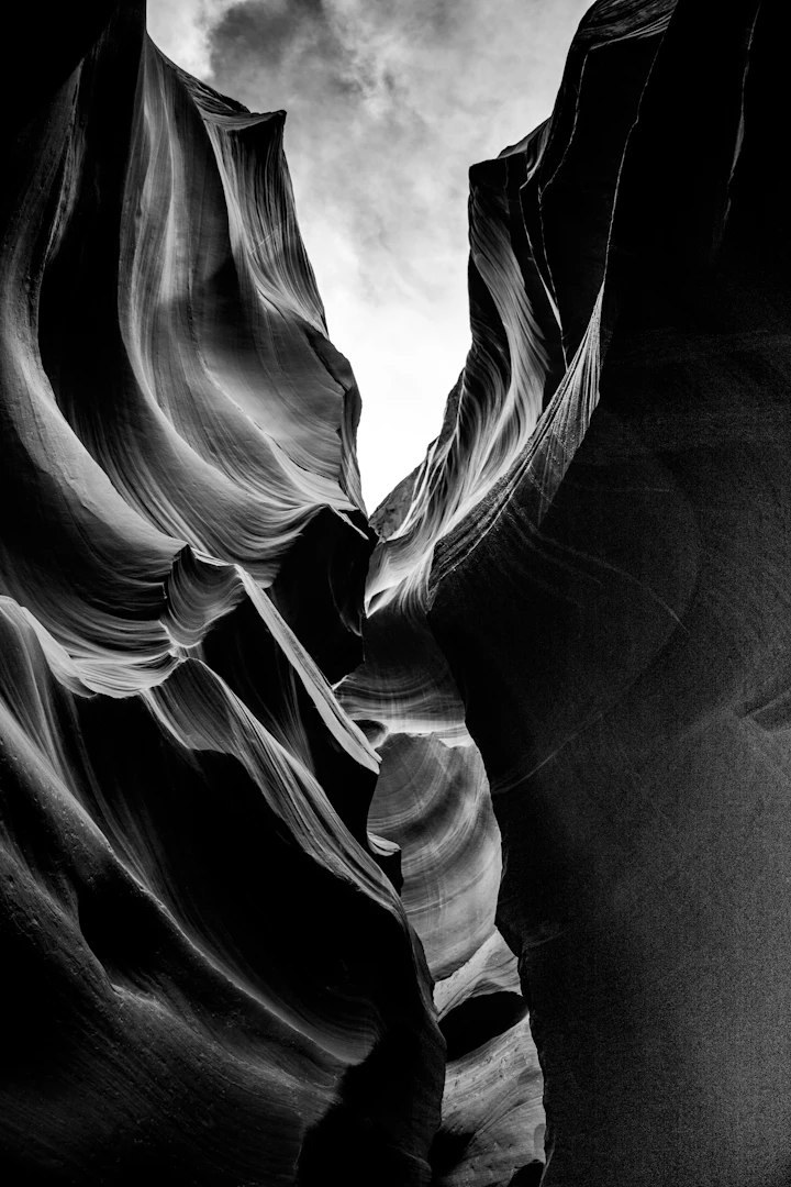 A black-and-white photograph of a canyon — stillness rendered in tonal greys, in the spirit of Mateus Andrade's hour-by-hour landscape series