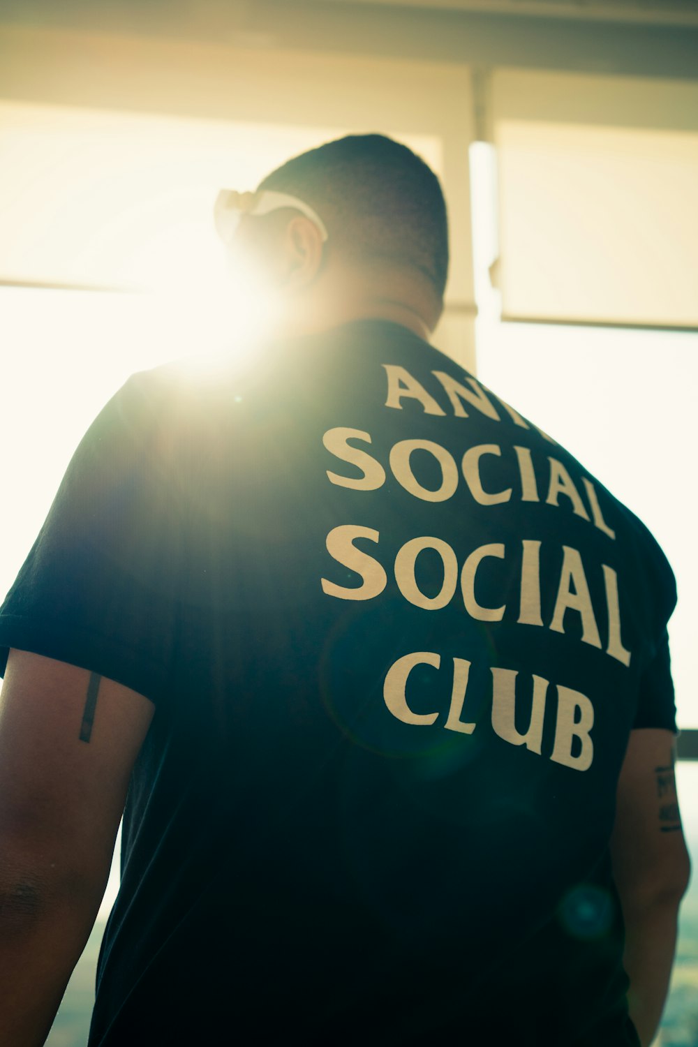 a man wearing a t - shirt that says anti social social club