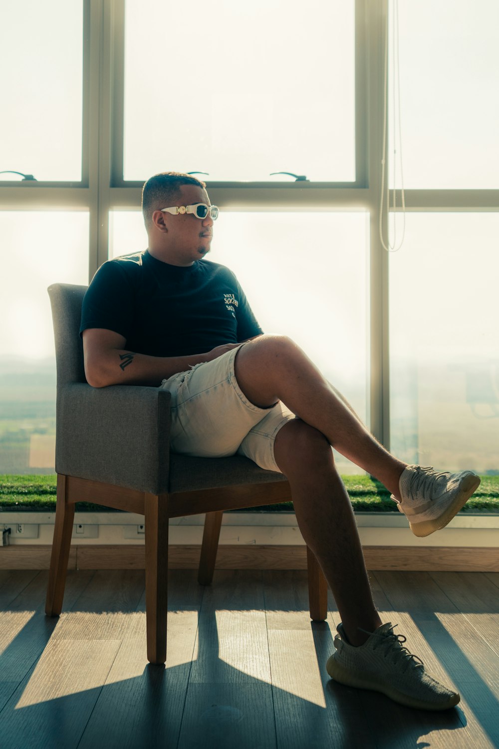 a man sitting in a chair in front of a window