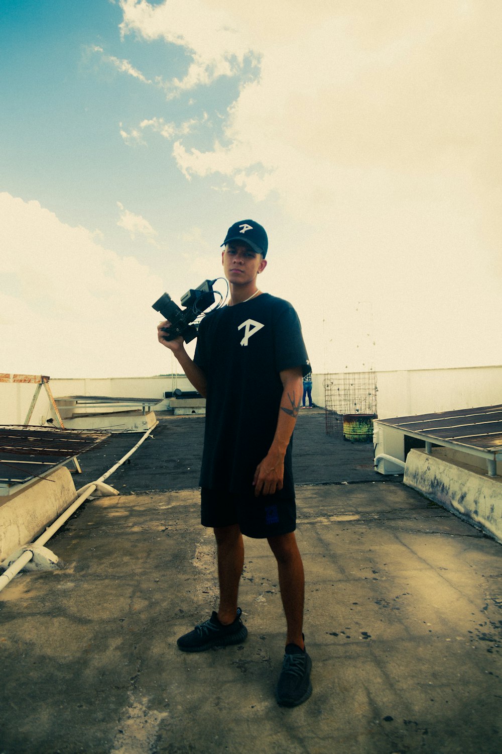 a man holding a skateboard on top of a roof