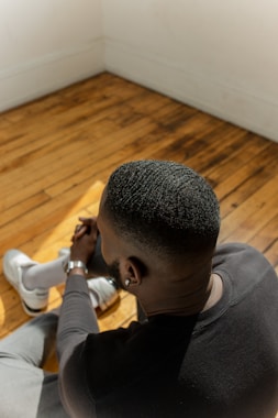a man sitting on the floor looking down at something