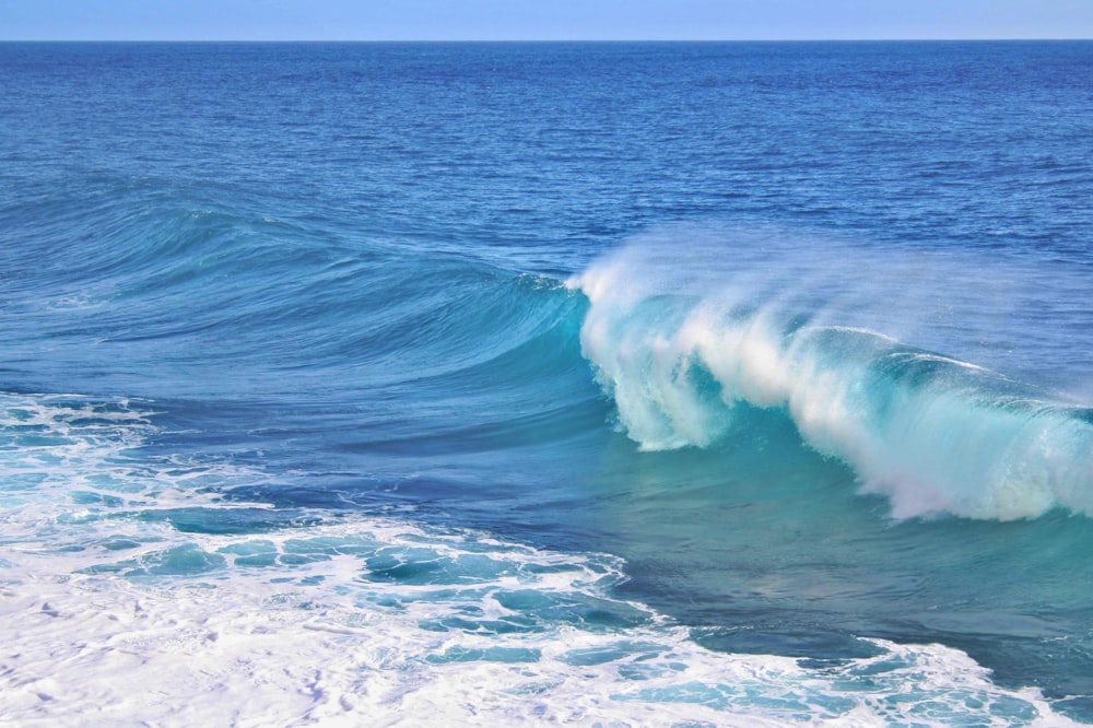 a large blue wave breaking into the ocean