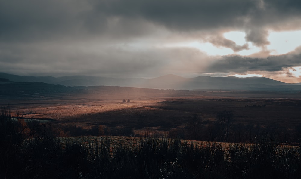 El sol brilla a través de las nubes sobre un campo