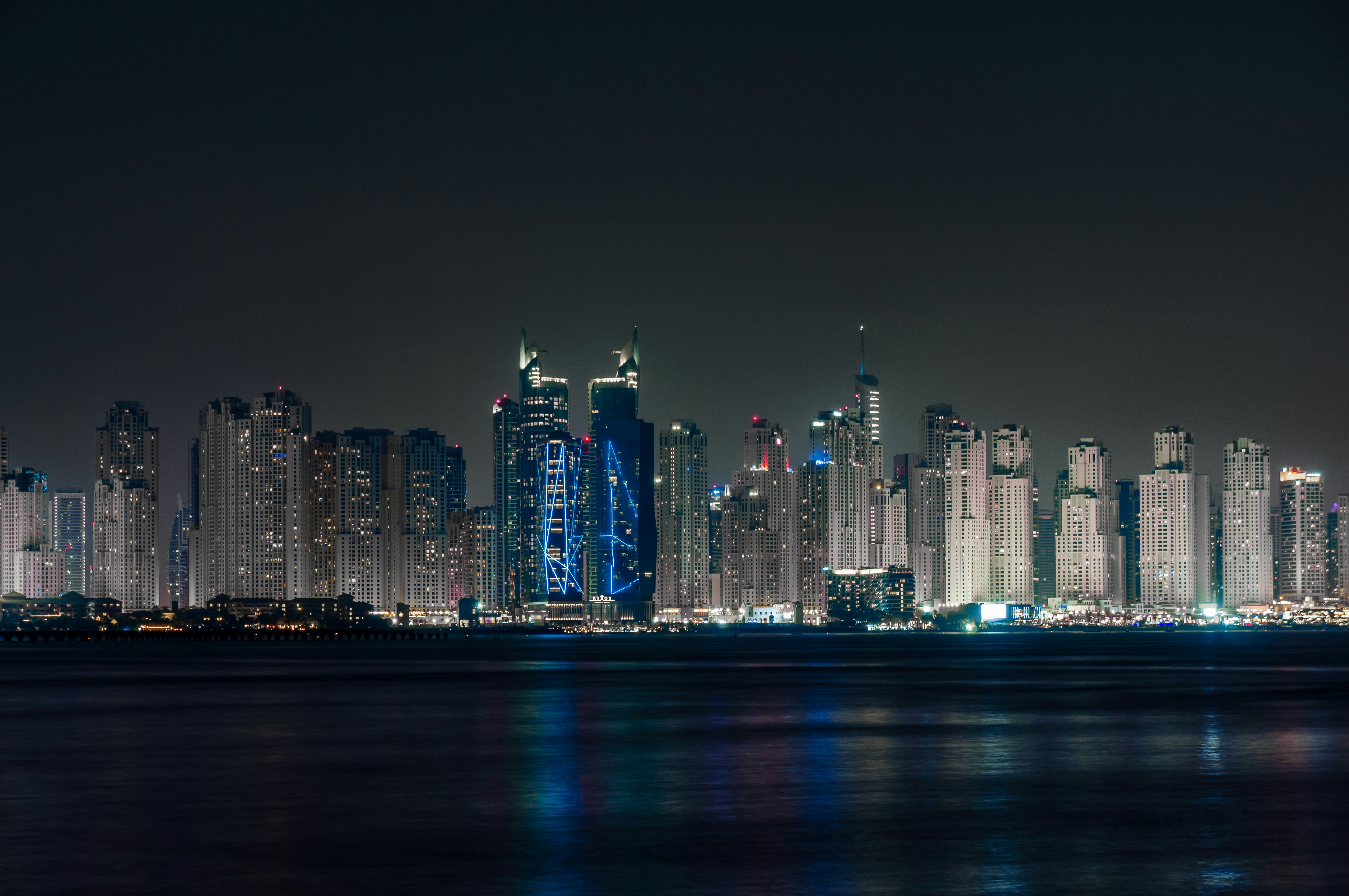 Eine Skyline der Stadt bei Nacht mit Lichtern, die vom Wasser reflektiert werden