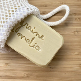 Soft white soap noodles spilling gently from a burlap sack onto a table