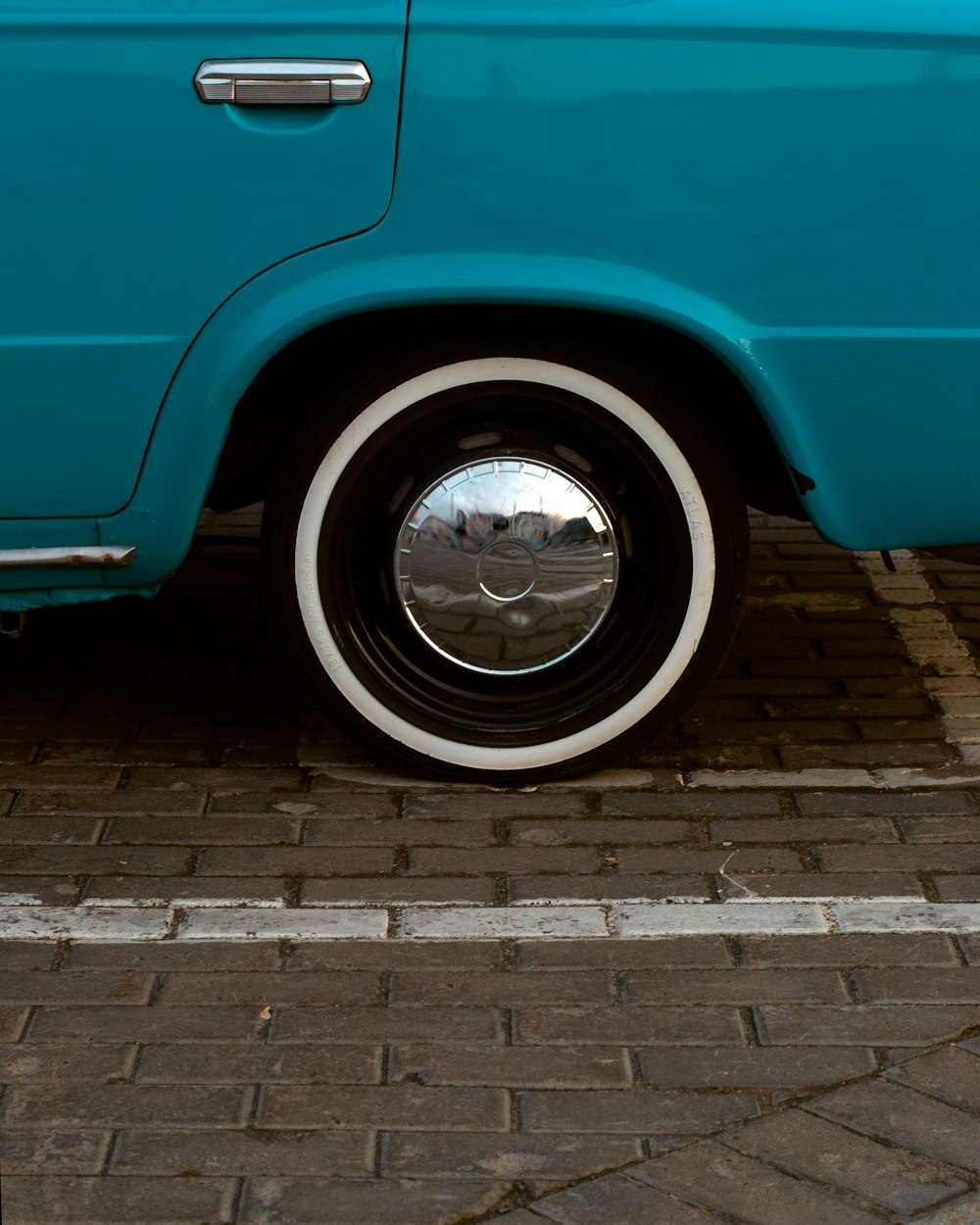 a close up of a car tire on a brick road