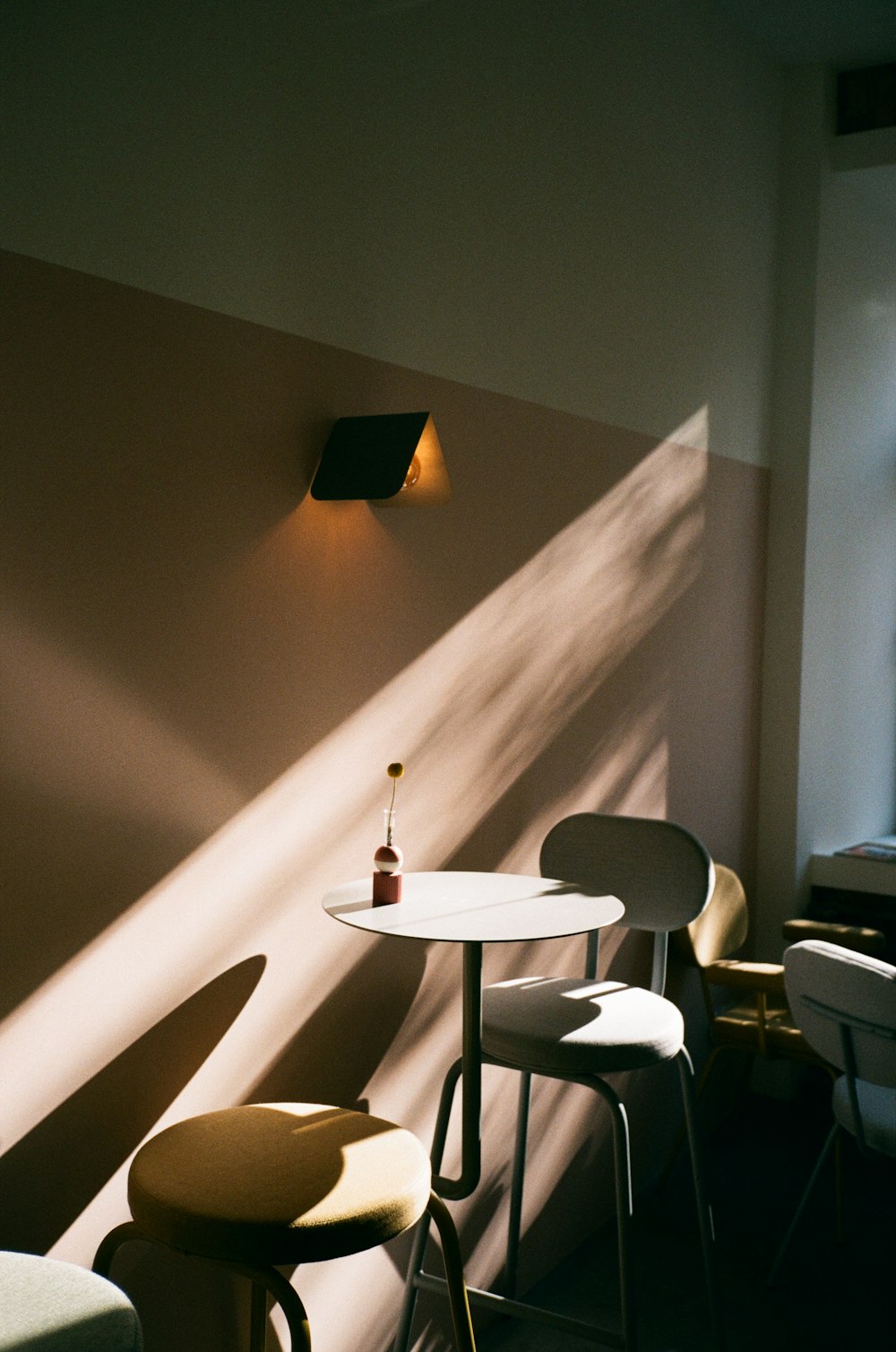 a table and chairs in a room with a wall light