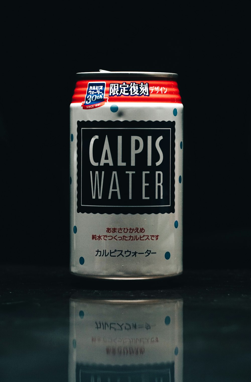a can of calpis water on a reflective surface