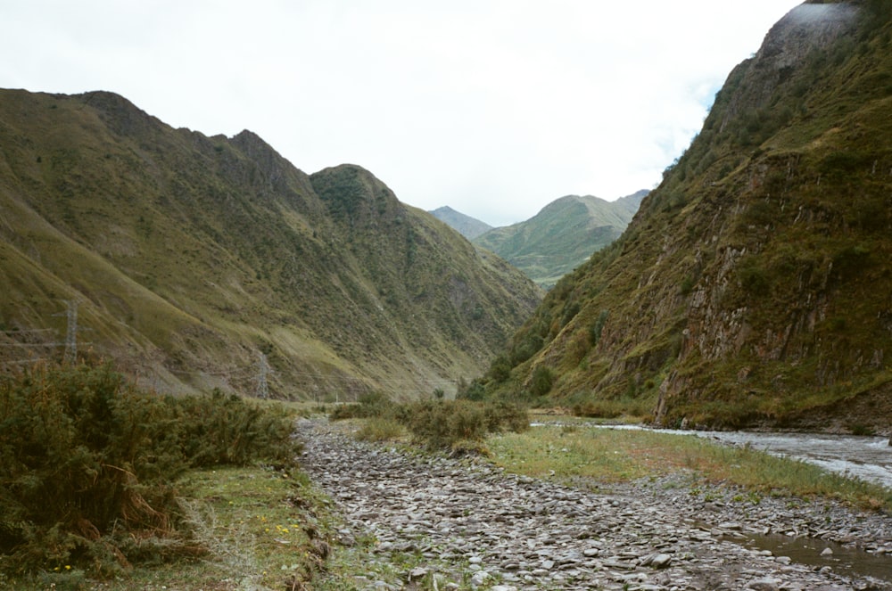 a river running through a valley surrounded by mountains
