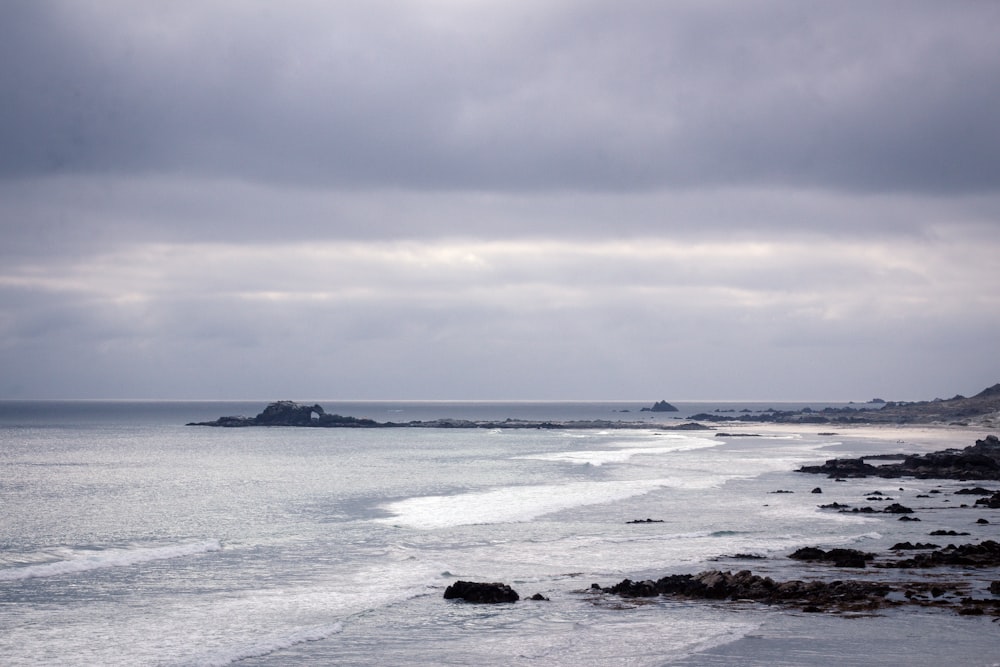 a view of the ocean from a rocky shore