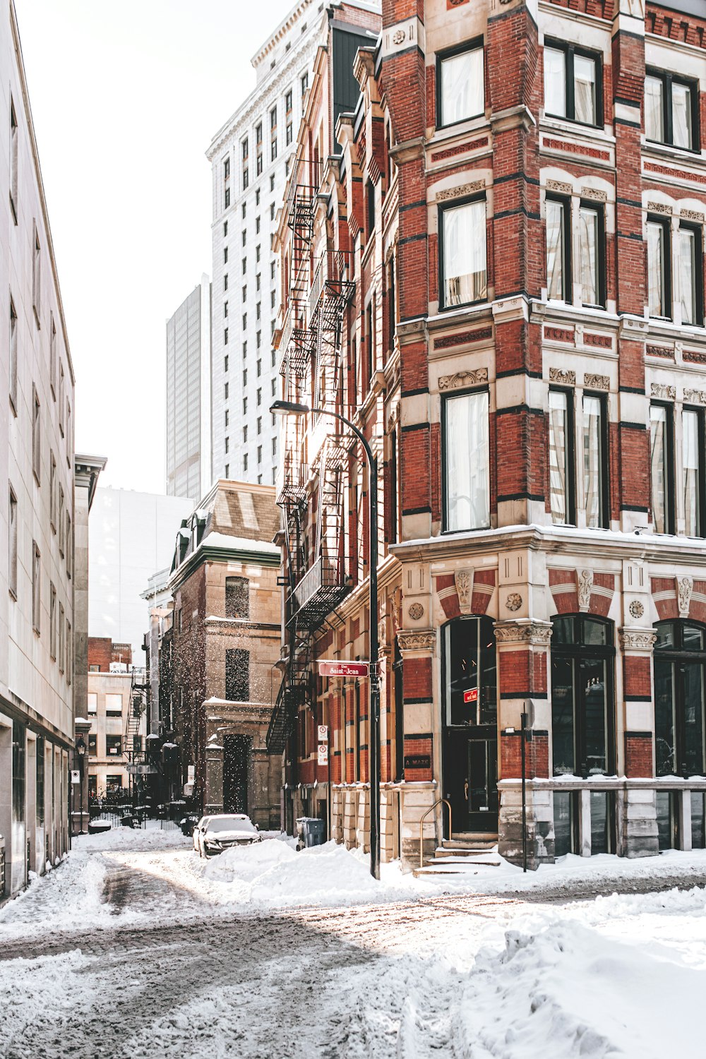 a snowy street in a large city with tall buildings