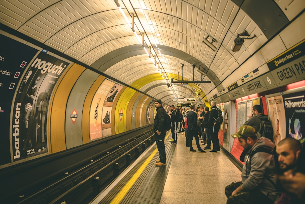 a group of people standing on a subway platform