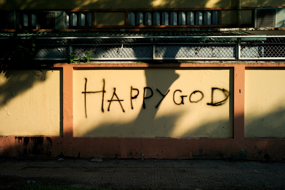 a shadow of a person on a wall with the words happy god written on it