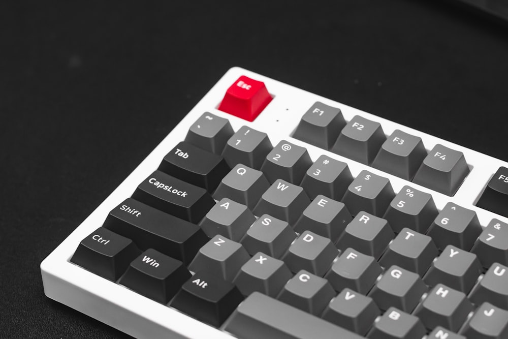 a computer keyboard with a red button on it