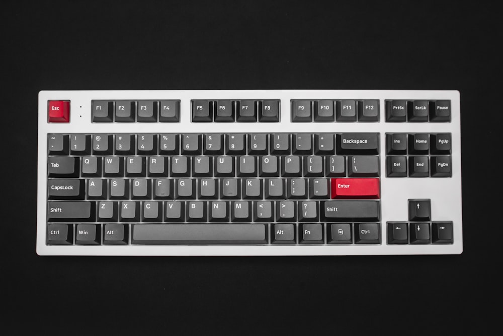 a black and white keyboard with red keys