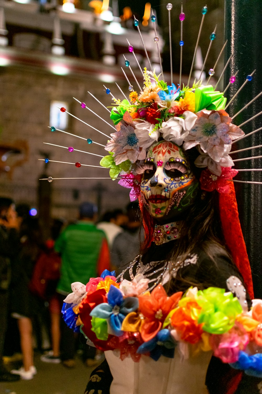 a woman wearing a colorful mask and headdress