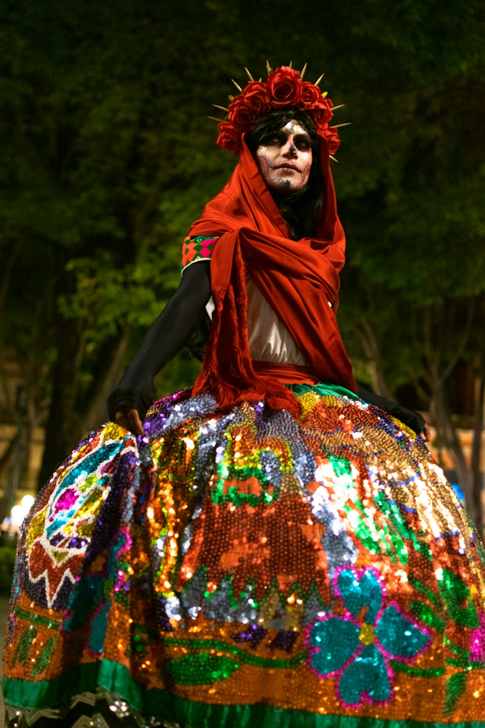 a woman in a costume sitting on top of a colorful object