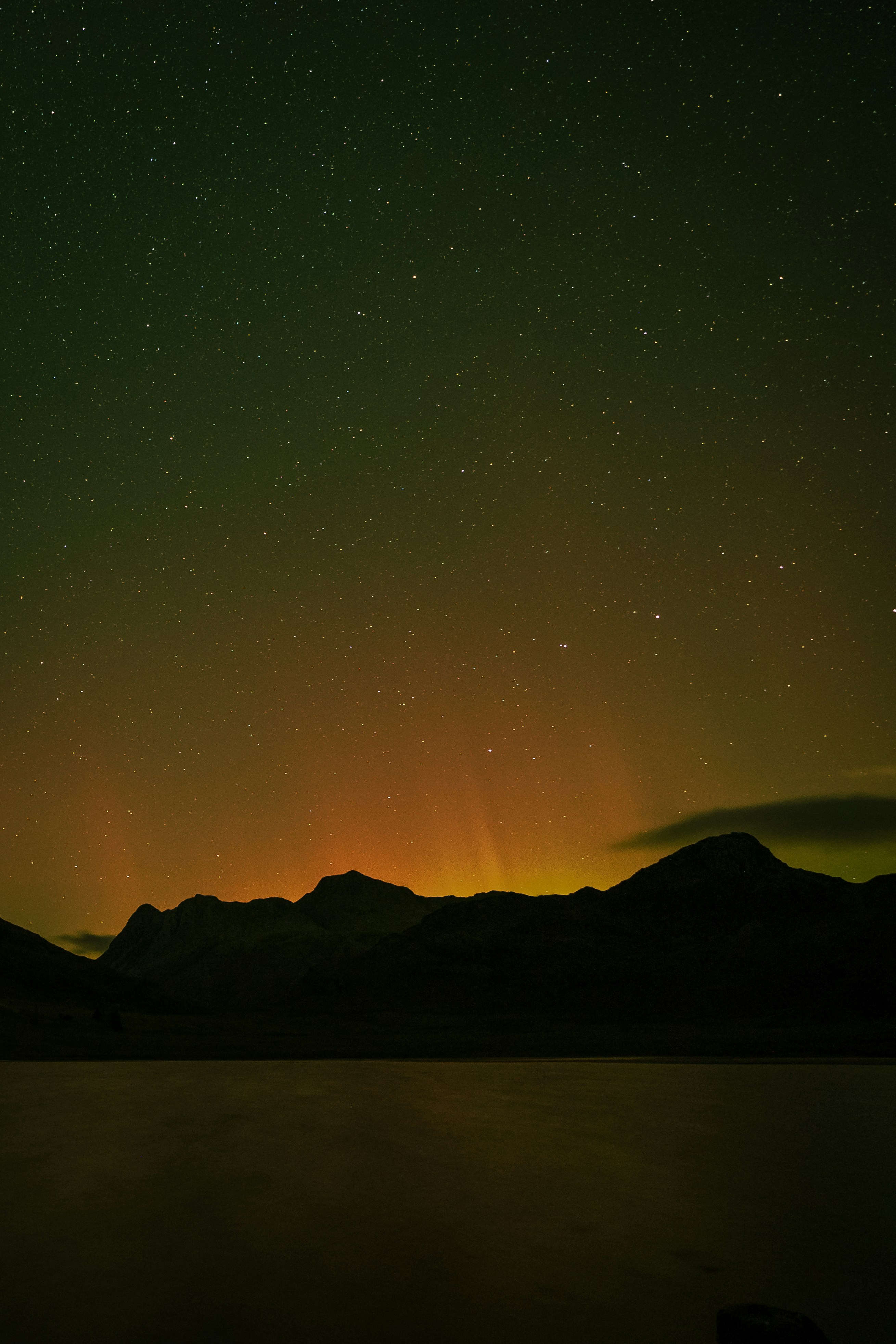 a night sky filled with stars above a mountain range
