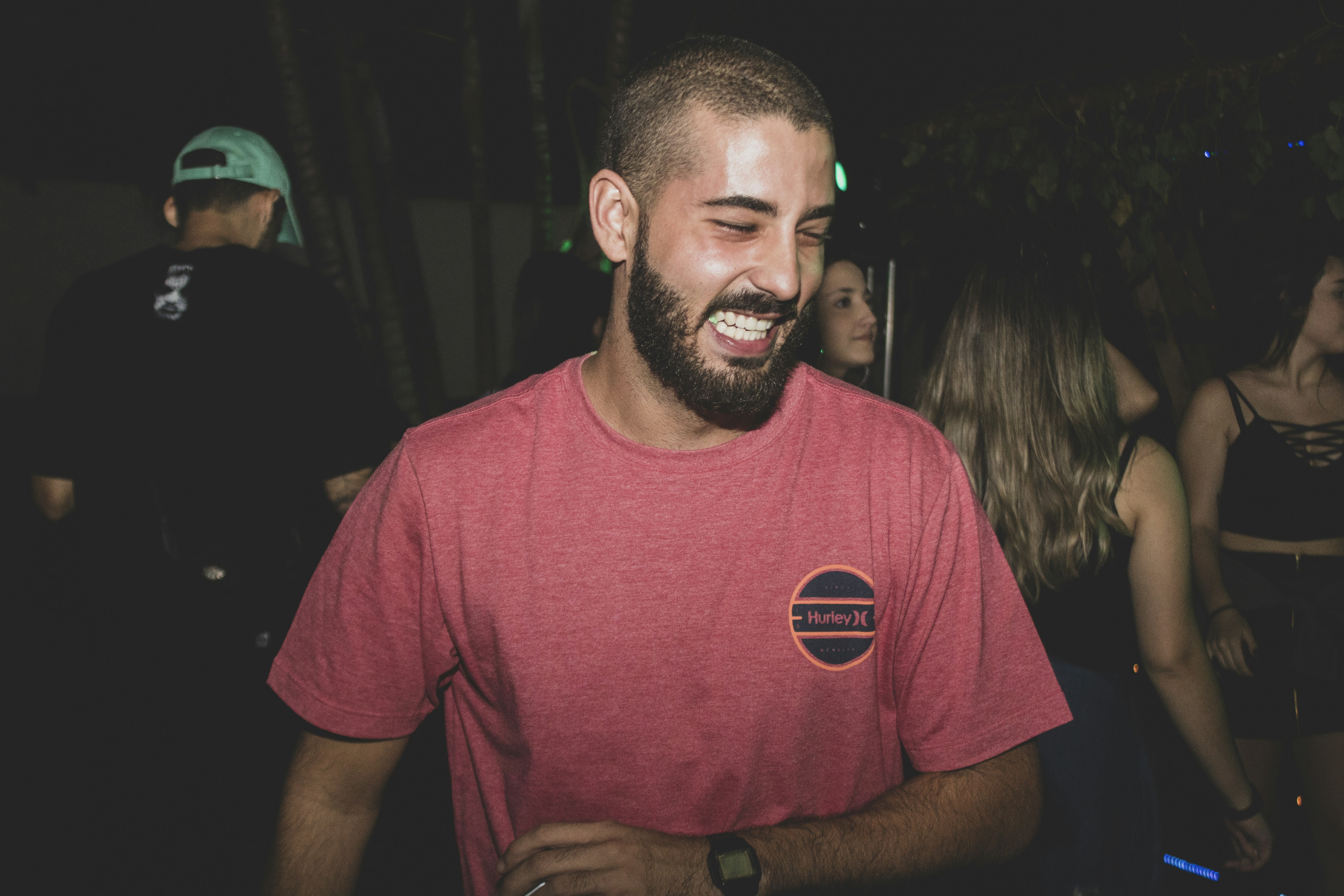 a man with a beard smiling at a party