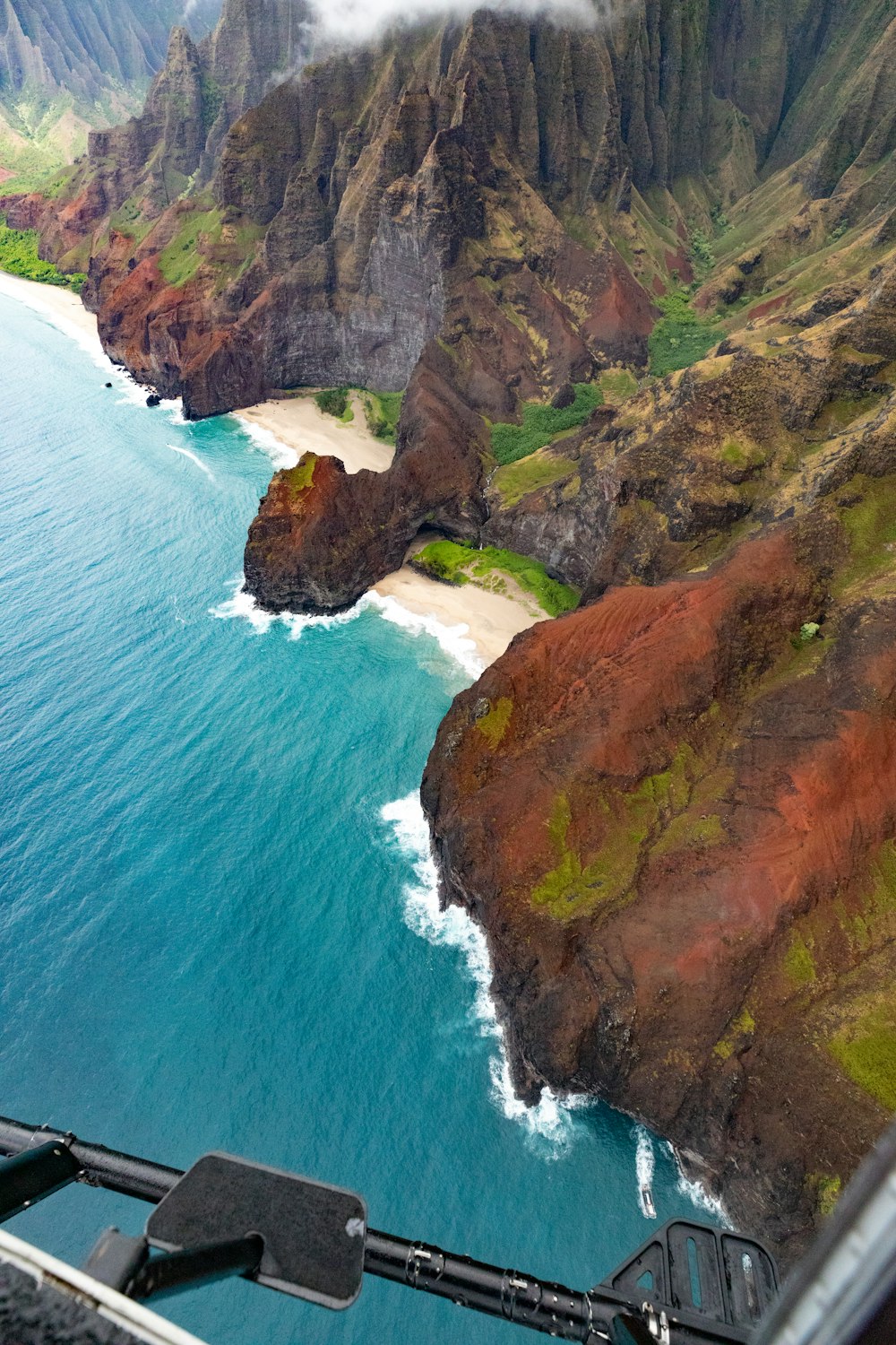 a view from a helicopter of a beach and mountains